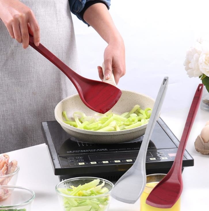 Il grano di legno disegna il silicone Turner del commestibile che cucina gli strumenti per la pentola antiaderante